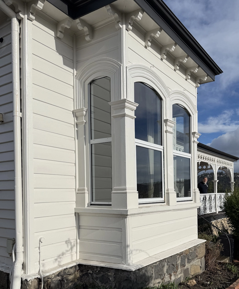 Ornate arched windows on a white Victorian house