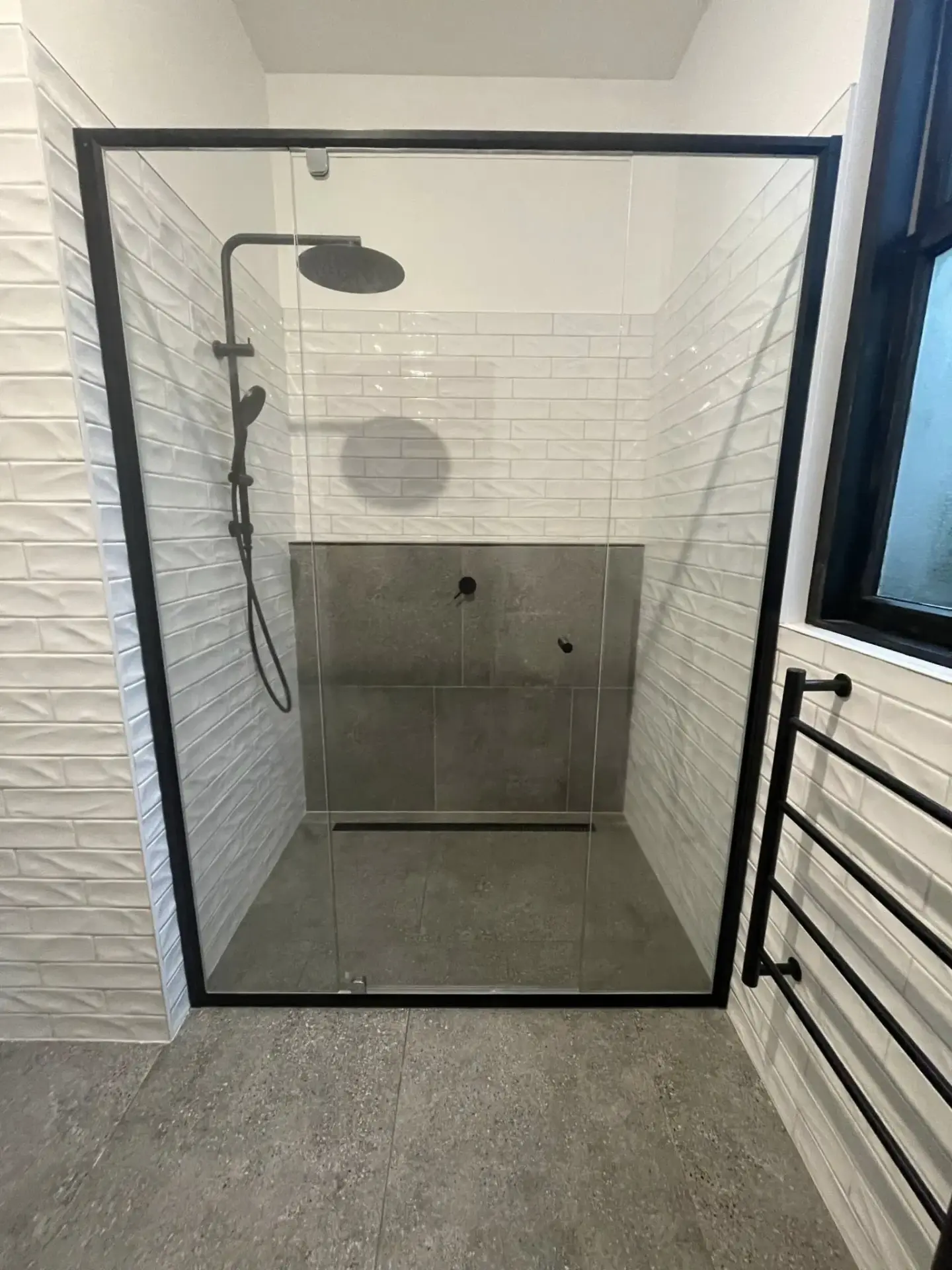 Modern shower with glass door and black frame