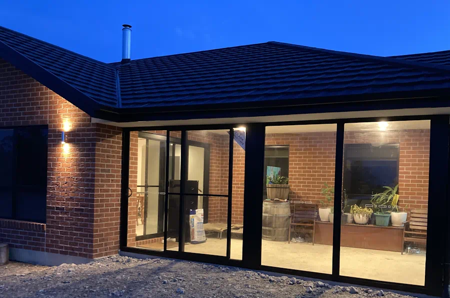 Brick house exterior with lit patio.